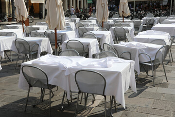 empty chairs and tables without customers in the alfresco bar of the square during the economic crisis caused by the coronavirus lockdowns