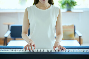 リビングでピアノを弾く日本人の女性