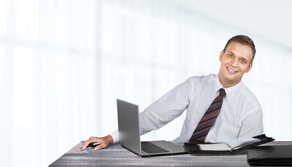 Fototapeta premium Young smiling man in glasses using laptop sitting at home desk, watching webinar studying online,