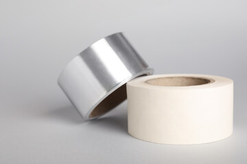 Two rolls of adhesive tape on light grey background
