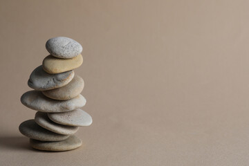 Fototapeta na wymiar Stack of stones on beige background, space for text. Harmony and balance concept