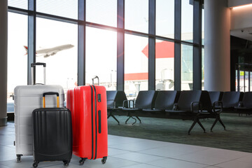 Stylish suitcases in waiting area at airport terminal - obrazy, fototapety, plakaty