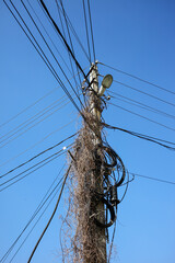 Electric pole with wires against the sky.