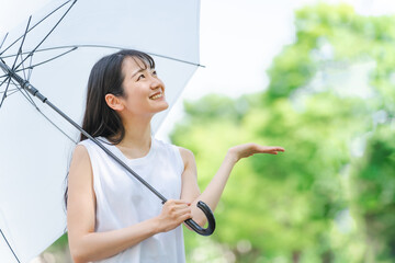 梅雨に傘を持ったアジア人女性(雨上がり・笑顔)
