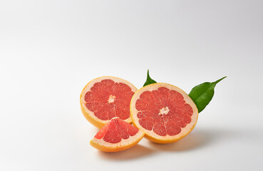 Grapefruit halves and slice on white background.