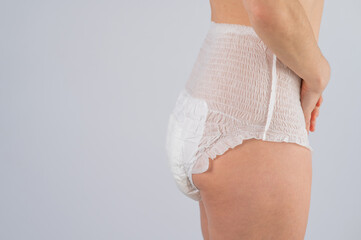 Side view of a Woman in adult diapers on a white background. Incontinence problem.  - obrazy, fototapety, plakaty