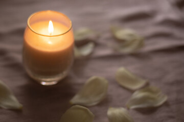 Blurred burning candle with flower petals