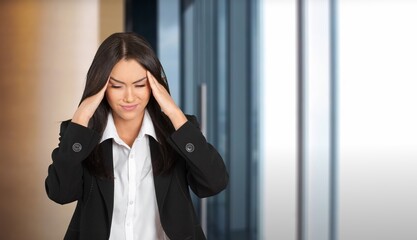 Stressed  woman touching his temples and having headache on background