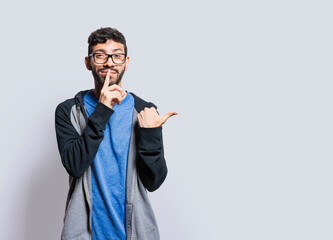 Mysterious person pointing to the side with his fingers on isolated background, Mysterious man...