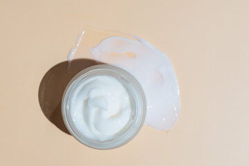 Skincare cosmetic cream or lotion swatch smear smudge on beige color background. White creamy hygiene beauty product in a jar. flat lay, copy space