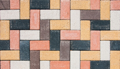 The city sidewalk is lined with multi-colored road tiles. View from above.