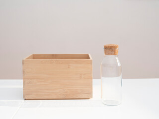 wooden box and empty glass bottle on table, front view