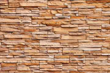 Brick wall cladding with narrow natural stones of various sizes and shapes.