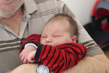 bébé dans les bras du grand père