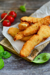 
 Crispy  deep Fried home made    Chicken strips Breaded  with  almond flour chicken  breast fillets  with chilly peppers and fresh   basil on wooden rustic background. Ketogenic diet food