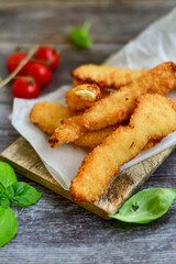 
 Crispy  deep Fried home made    Chicken strips Breaded  with  almond flour chicken  breast fillets  with chilly peppers and fresh   basil on wooden rustic background. Ketogenic diet food
