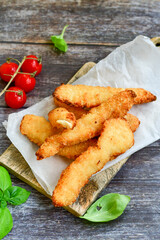 
 Crispy  deep Fried home made    Chicken strips Breaded  with  almond flour chicken  breast fillets  with chilly peppers and fresh   basil on wooden rustic background. Ketogenic diet food