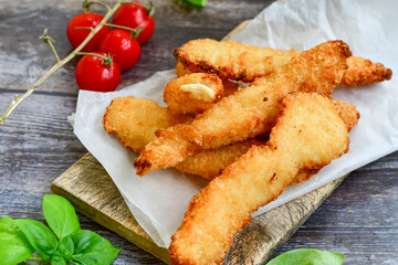 
 Crispy  deep Fried home made    Chicken strips Breaded  with  almond flour chicken  breast fillets  with chilly peppers and fresh   basil on wooden rustic background. Ketogenic diet food