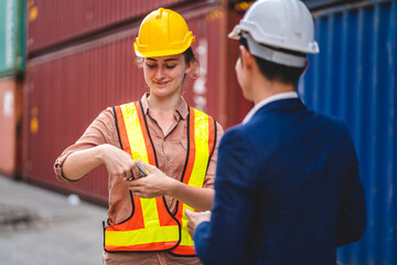 Professional engineer container cargo foreman team in helmets working standing and using walkie talkie checking stock into container for loading.logistic transport and business industry export