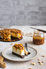 homemade cheesecake with peanuts and caramel on a light background