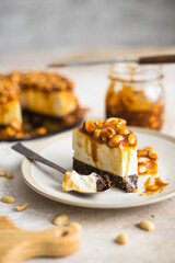 homemade cheesecake with peanuts and caramel on a light background
