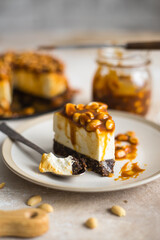 homemade cheesecake with peanuts and caramel on a light background