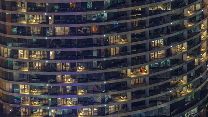 Fototapeta na wymiar Outside view of windows in apartments of a high class building at night timelapse
