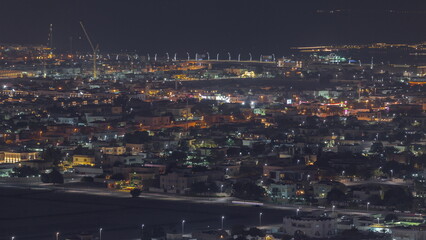 Aerial view of many apartment houses and villas in Dubai city night timelapse from skyscraper in downtown