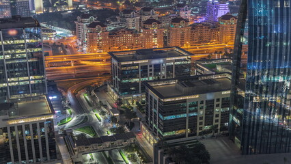 Aerial panorama of Downtown Dubai with office buildings and traffic on a street night timelapse from above, UAE