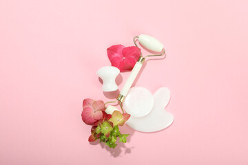 Face care concept with gua sha kit on pink background