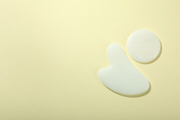 Face care concept with gua sha on soft background