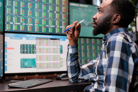 Busy Financial Analyst Sitting At Workstation While Reviewing Investment Fund Data And Real Time Statistics. Attentive Forex Stock Market Trader Being Mindful While Analyzing Buy And Sell Values.