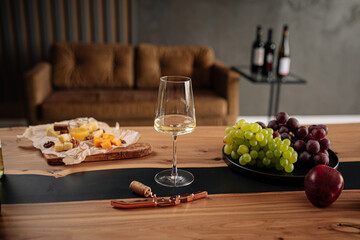 White wine glass with appetizers on wooden table