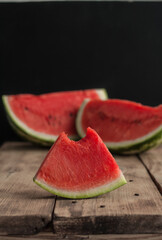 Fresh sliced watermelon wooden background, ripe striped watermelon, close-up of a fresh slice of red watermelon, sweet harvest.