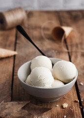 Homemade ice cream balls in a deep bowl on a wooden background