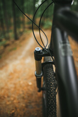 Close up of a suspension air fork on a mountain bike. Riding a bicycle in the forest. Concept of having fun while riding outdoors on a cross country bike. Hydraulic suspension absorbs offroad paths