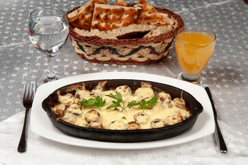 Oven-baked cheddar mushrooms. The mushroom on the clay plate is on the dining table.