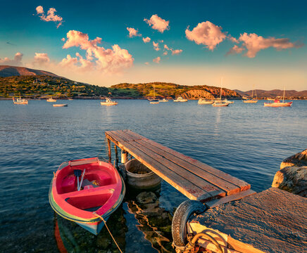 Small wooden pier on Nuevo Loca Beach. Captivating sunrise on Aegean sea. Stunning morning scene of outskirts of Anavyssos town, Greece, Europe. Traveling concept background.