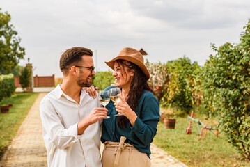 Young smiling couple tasting wine at winery vineyard - Friendship and love concept with young...