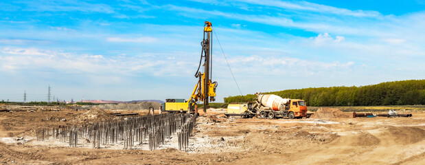 Hydraulic drilling machine at the construction site makes piles. Pile field. Modern drilling rig....