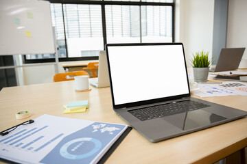 Notebook laptop computer and business paperwork on meeting table.