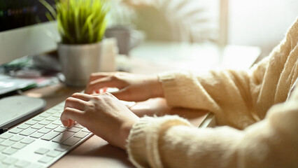Female office worker or businesswoman hands typing on computer keyboard