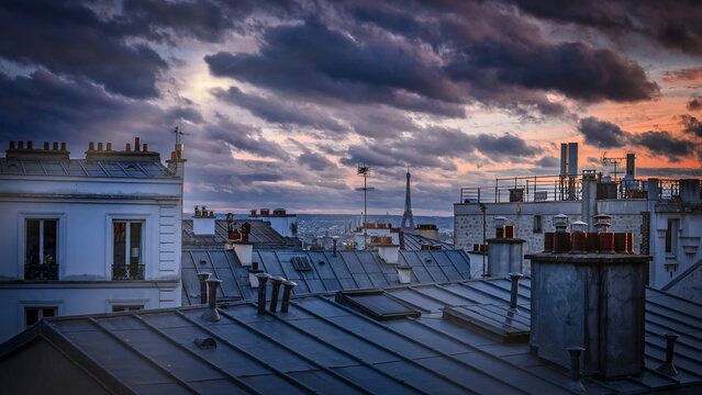 Colorful cloudy twilight above the rooftops of Paris, France viewed from the top of the Montmartre hill.