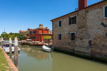 Small port of the Torcello island in Venetian lagoon with motor boats and two traditional water...
