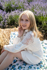 Attractive young woman in white fashion dress posing in lavender