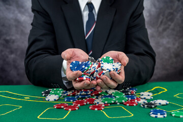 Man in suit holding poker chips playing in the casino