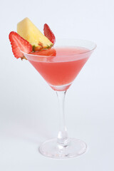Martini glass whith Cold fresh pink cocktail decorated with strawberries and pineapple isolated on white background