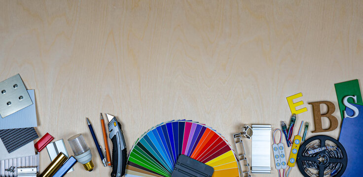Advertising agency tools, construction materials and samples on plywood background. Top view. No people.