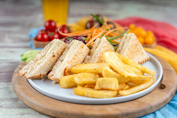 Traditional sandwich made from slices of toasted bread, cheese served with orange juise ,fried patatoe, salads and different colors of tomatoes.