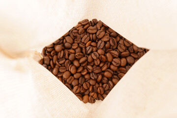 A view inside the bag on fragrant and aromatic roasted coffee beans. Selective focus